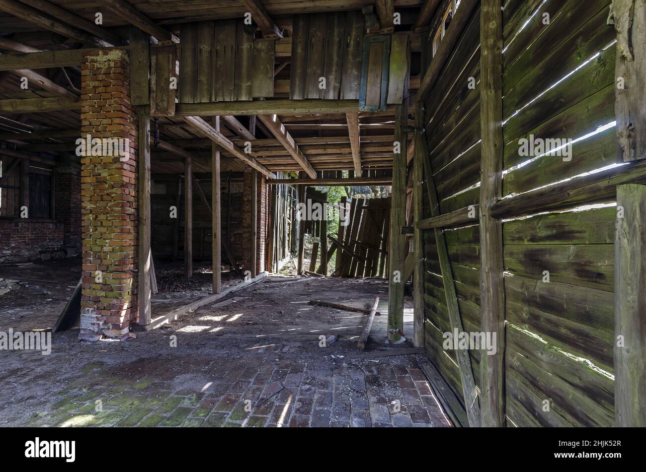 Vecchio fienile rustico abbandonato con pareti di legno fuoriusciti e cancello rotto Foto Stock