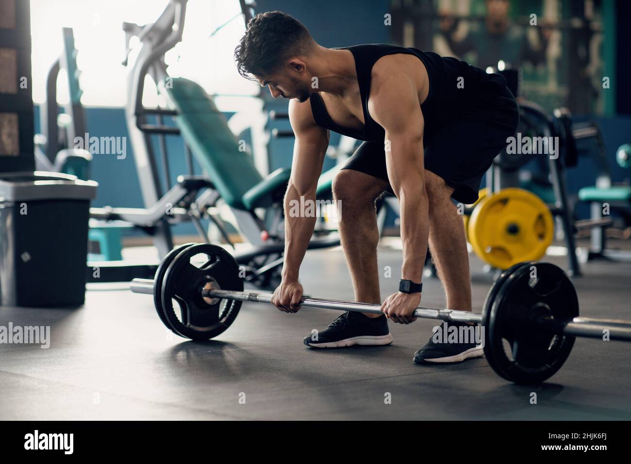 Ritratto di muscoloso Medio Oriente Guy facendo deadlift allenamento alla moderna palestra Foto Stock