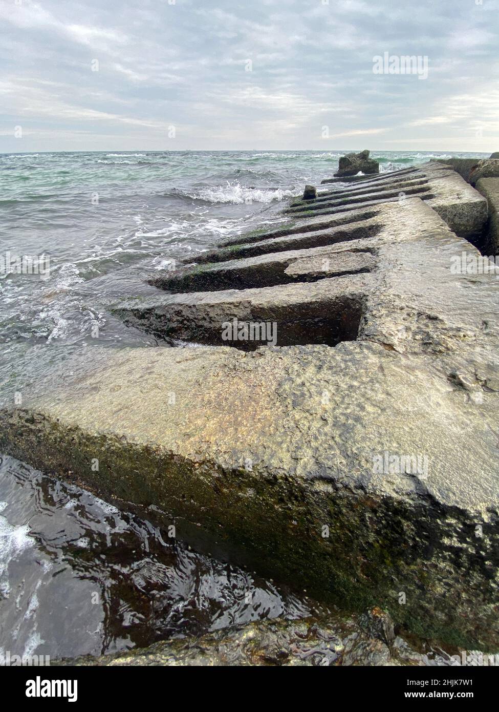 Colpo verticale di una vecchia griglia di cemento sulla riva del mare in  acqua Foto stock - Alamy