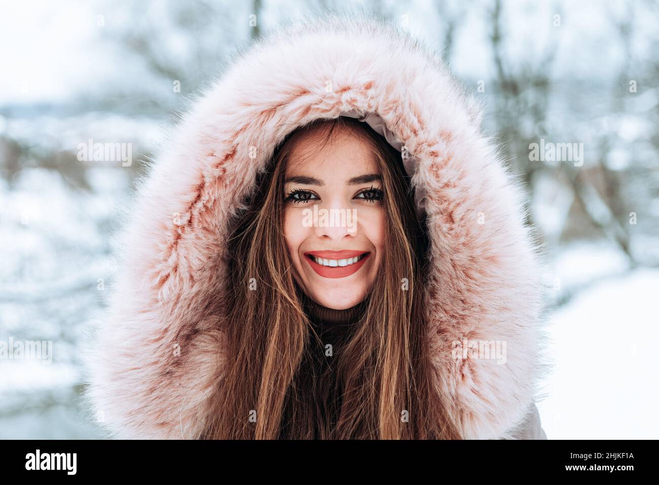 Ritratto all'aperto di una giovane donna in una giacca invernale in pelliccia Foto Stock