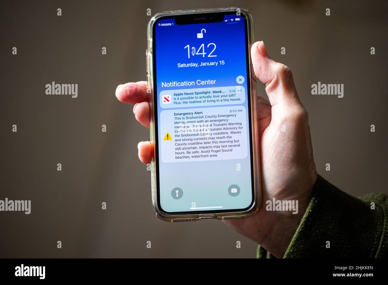 Everett, WA - USA -01-15-2021: IPhone Holding con avviso di emergenza circa possibile tsunami nella contea di Snohomish Foto Stock