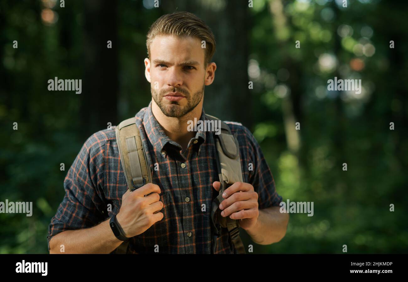 Viaggi, avventura, vacanza. Uomo con zaino escursioni in legno. Hipster bearded che viaggia nella foresta. Foto Stock
