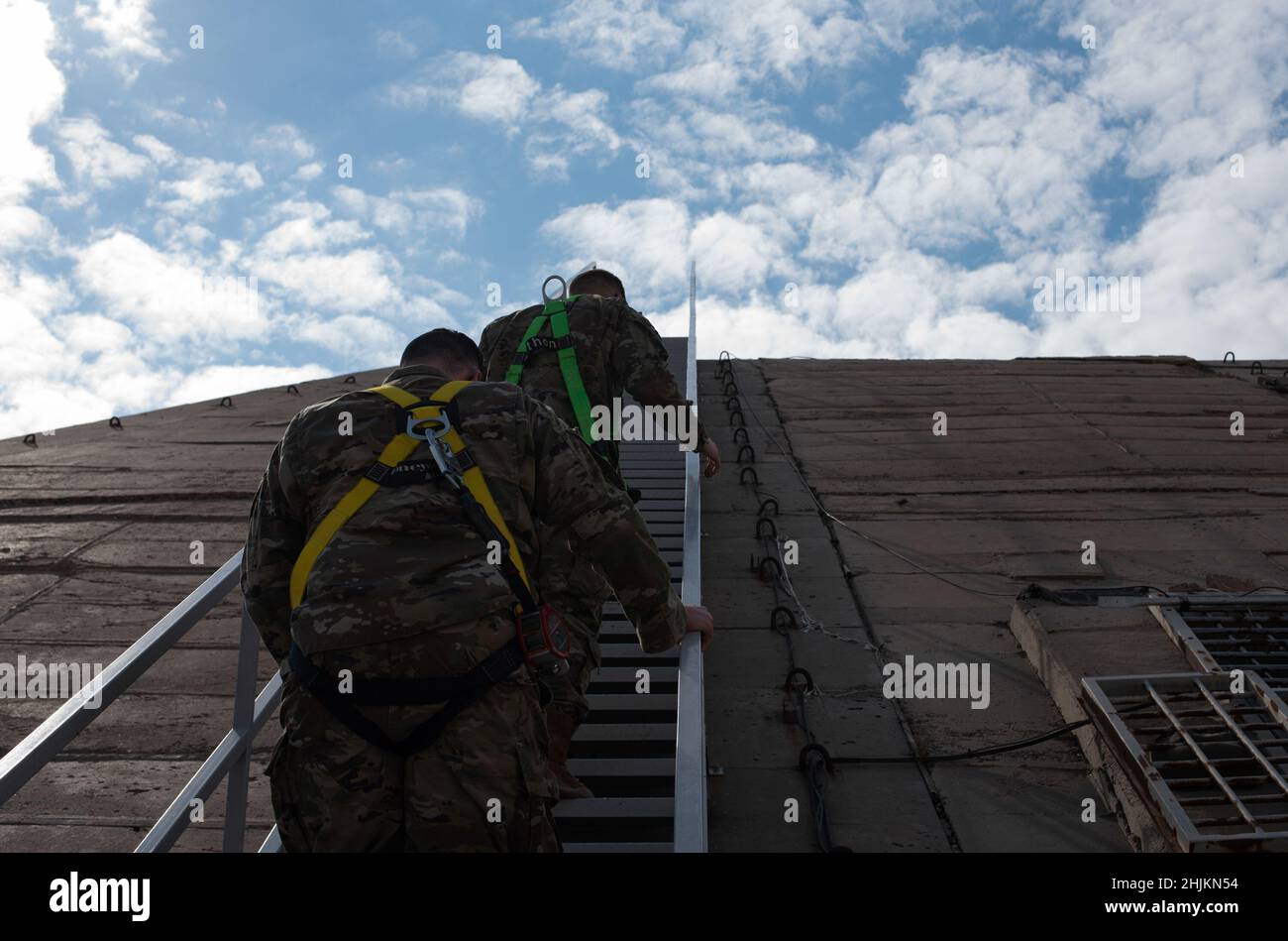 L'Air Force Senior Airman statunitense Jakob Savage (a sinistra) e lo staff USAF Sgt. Daniel Sullivan, entrambi gli esperti di previsioni meteo assegnati allo Squadrone di supporto delle operazioni di spedizione 407th, ascende un hangar dell'aereo alla base aerea di Ali al Salem, Kuwait, 3 gennaio 2022. Sullivan e Savage hanno effettuato un'ispezione mensile di un radar Doppler portatile, utilizzato per prevedere il tempo all'interno dell'area immediatamente circostante l'ASAB. Il volo meteorologico EOSS del 407th è responsabile dell'identificazione di eventuali cambiamenti climatici che impedirebbero agli aerei congiunti e di coalizione, e ai membri del servizio di base di svolgere le loro mansioni. Foto Stock