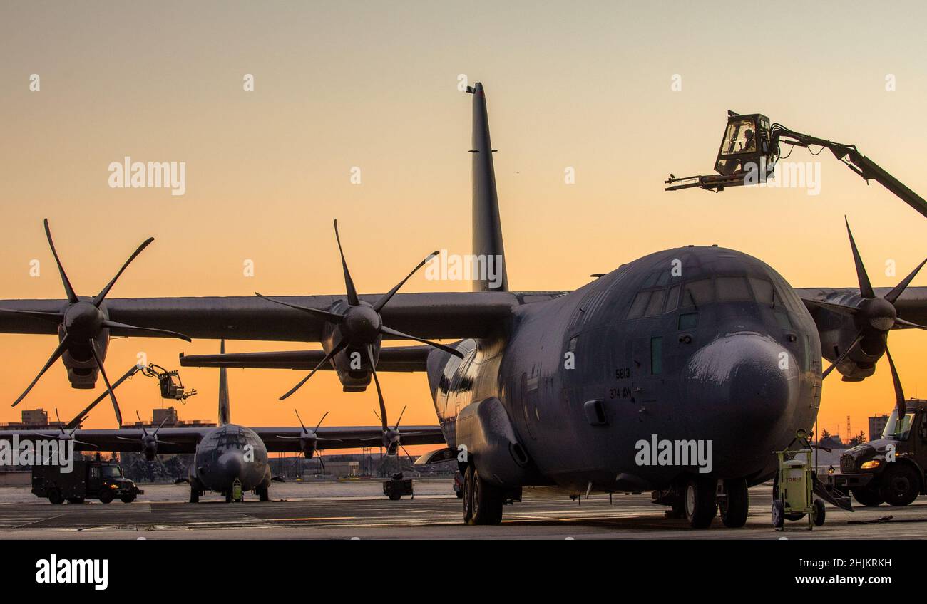 Airmen assegnati al 374th Aircraft Maintenance Squadron de-ICE a C-130J Super Hercules assegnato al 36th Airlift Squadron alla Yokota Air base, Giappone, 7 gennaio 2022. Lo sbrinatore utilizza acqua riscaldata miscelata con glicole per scongelare il ghiaccio e impedire la formazione di ghiaccio futuro sull'aereo. Foto Stock