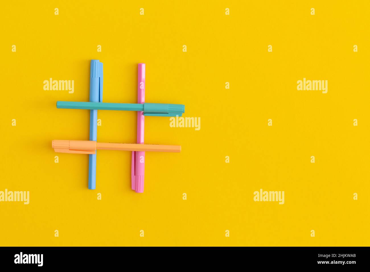 Hashtag segno fatto di teschi colorati su sfondo giallo Foto Stock