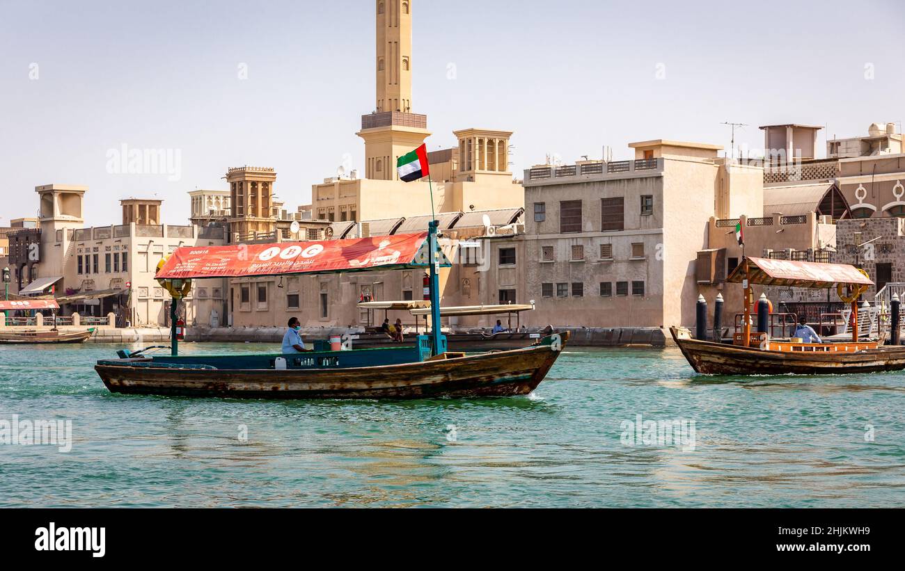 Dubai, Emirati Arabi Uniti, 24.09.21. Tradizionale barca araba 'Abra' in legno sul Dubai Creek, la vecchia Dubai e gli edifici e la moschea del quartiere storico di al Fahidi. Foto Stock