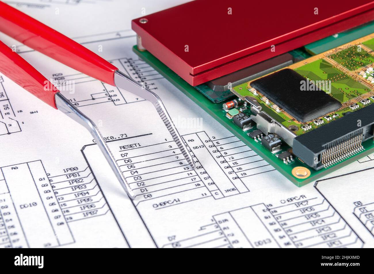 Scheda elettronica e pinzette sullo sfondo dello schema elettrico. Concetto per lo sviluppo e la progettazione di dispositivi elettronici. Foto Stock