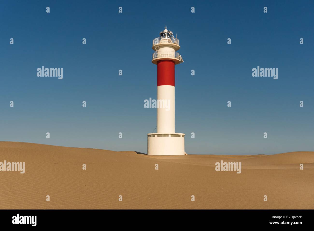 Faro di Delta del Ebro tra le dune di Fangar al tramonto in una giornata di sole Foto Stock