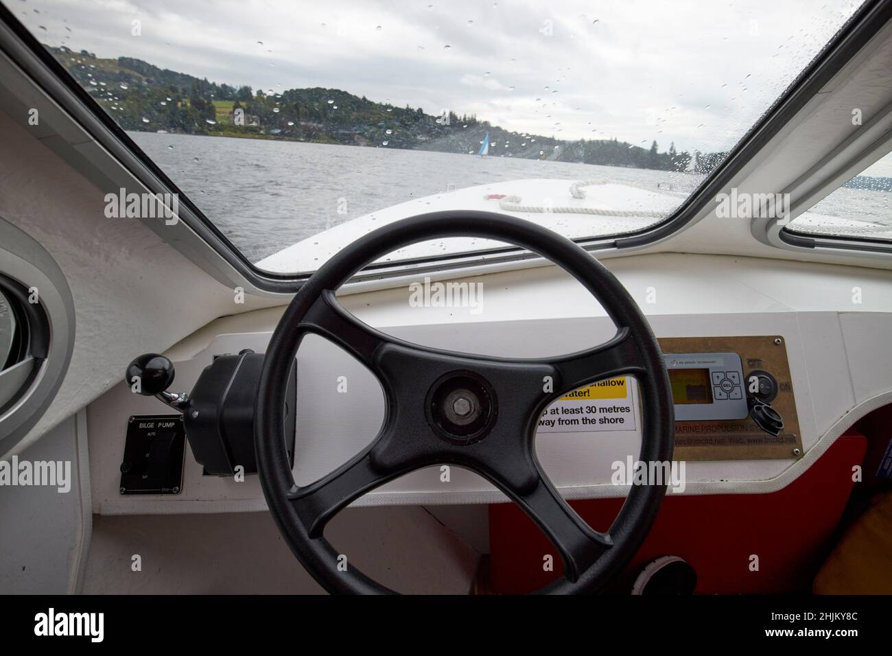 controllo del volante e della potenza su una piccola imbarcazione elettrica sul lago windermere lake district, cumbria, inghilterra, regno unito Foto Stock