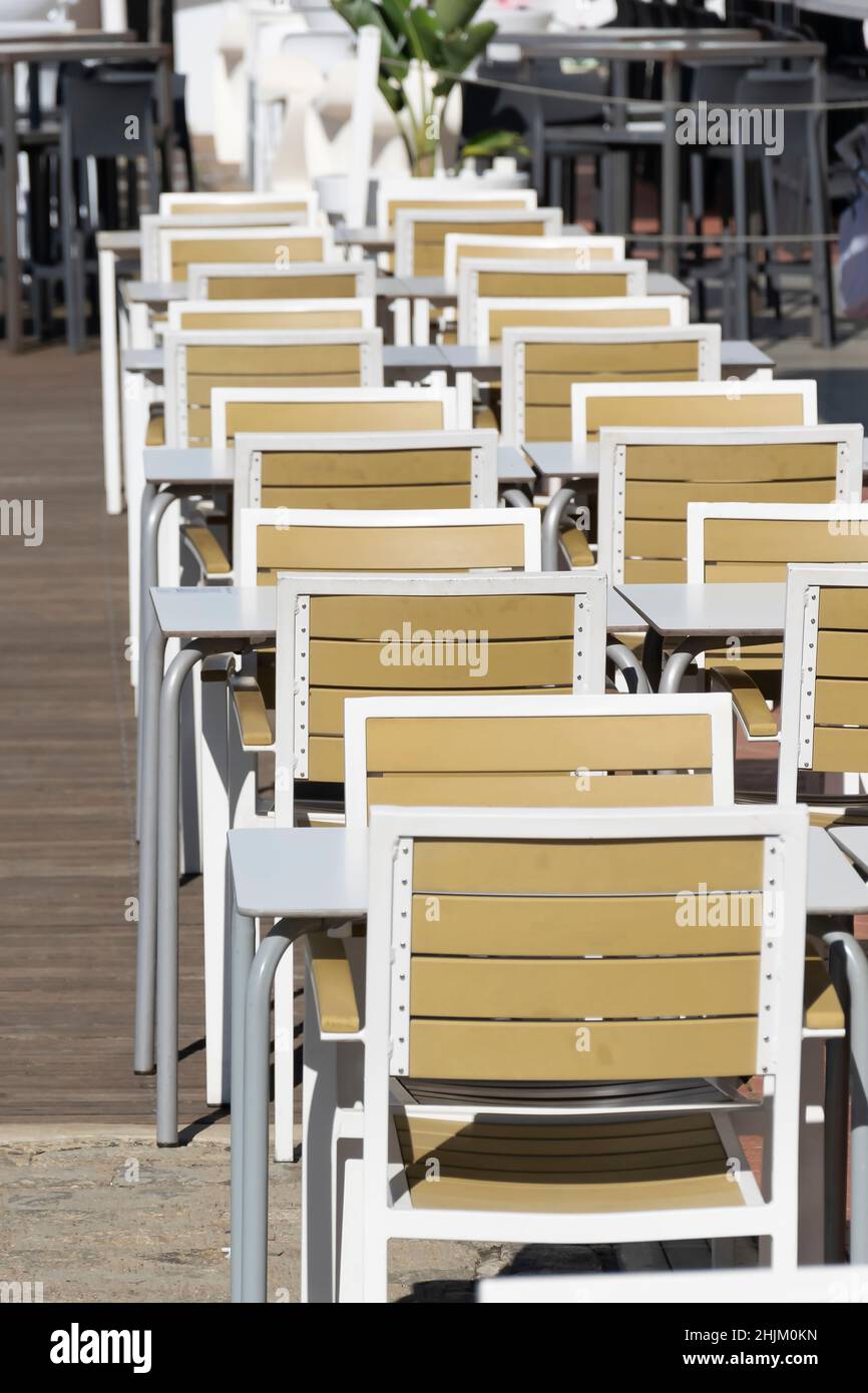 Tavoli di una terrazza disposti in fila con distanza di sicurezza Foto Stock