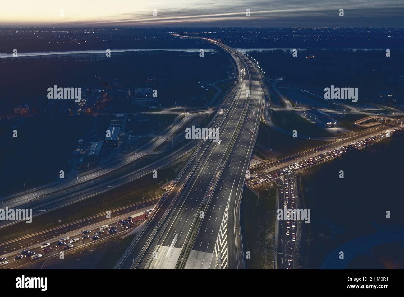 Incrocio stradale illuminato al crepuscolo, immagine tonata dell'industria dei trasporti Foto Stock