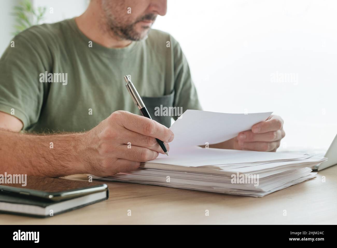 Telecommuter lettura documento cartaceo di progetto in home Office, focus selettivo Foto Stock