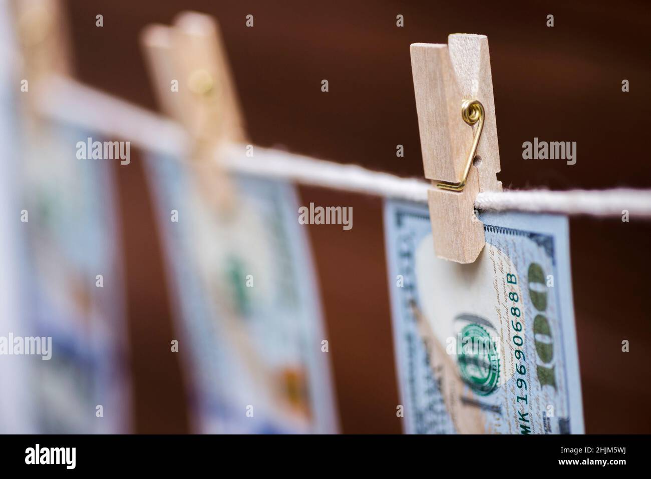 Le fatture americane del cento-dollaro sono appese su una corda con i clothespins di legno. Concetto di riciclaggio di denaro. Soldi sporchi. Foto Stock