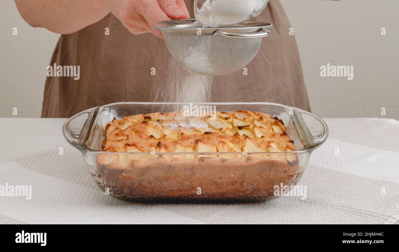 Torta di mele appena sfornata con biscotto a base ravvicinata sul tavolo da cucina, appena dal forno. Torta di condimenti con zucchero a velo. Foto Stock