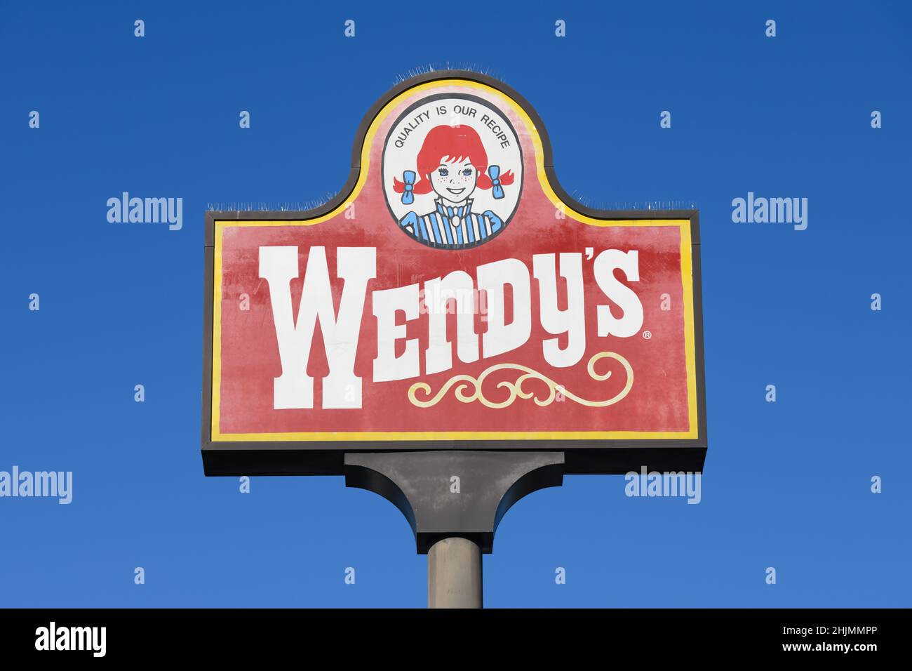 Marysville, WA, USA - 27 gennaio 2022; segnale elevato per il ristorante fast food Wendy's contro un cielo blu chiaro con logo aziendale Foto Stock