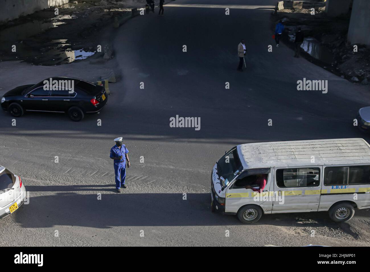 Nairobi, Kenya. 26th Jan 2022. Un poliziotto controlla il traffico durante l'ora di punta in una sezione della strada che è quasi completa del progetto Nairobi Expressway lungo la strada Mombasa. La costruzione dell'autostrada a pedaggio lunga 27,1km, la Nairobi Expressway continua e si prevede che sarà completata nel giugno 2022. La superstrada di Nairobi è destinata a decongest la città di Nairobi fornendo trasporti più veloci e affidabili. Credit: SOPA Images Limited/Alamy Live News Foto Stock