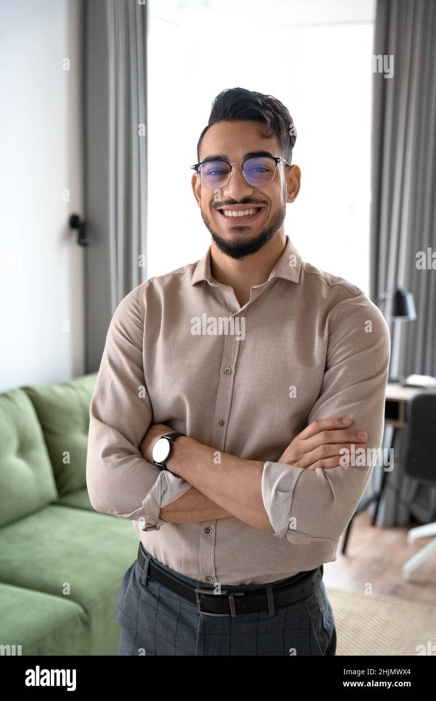 Ritratto dell'uomo d'affari indiano intelligente che guarda la macchina fotografica in ufficio a casa Foto Stock