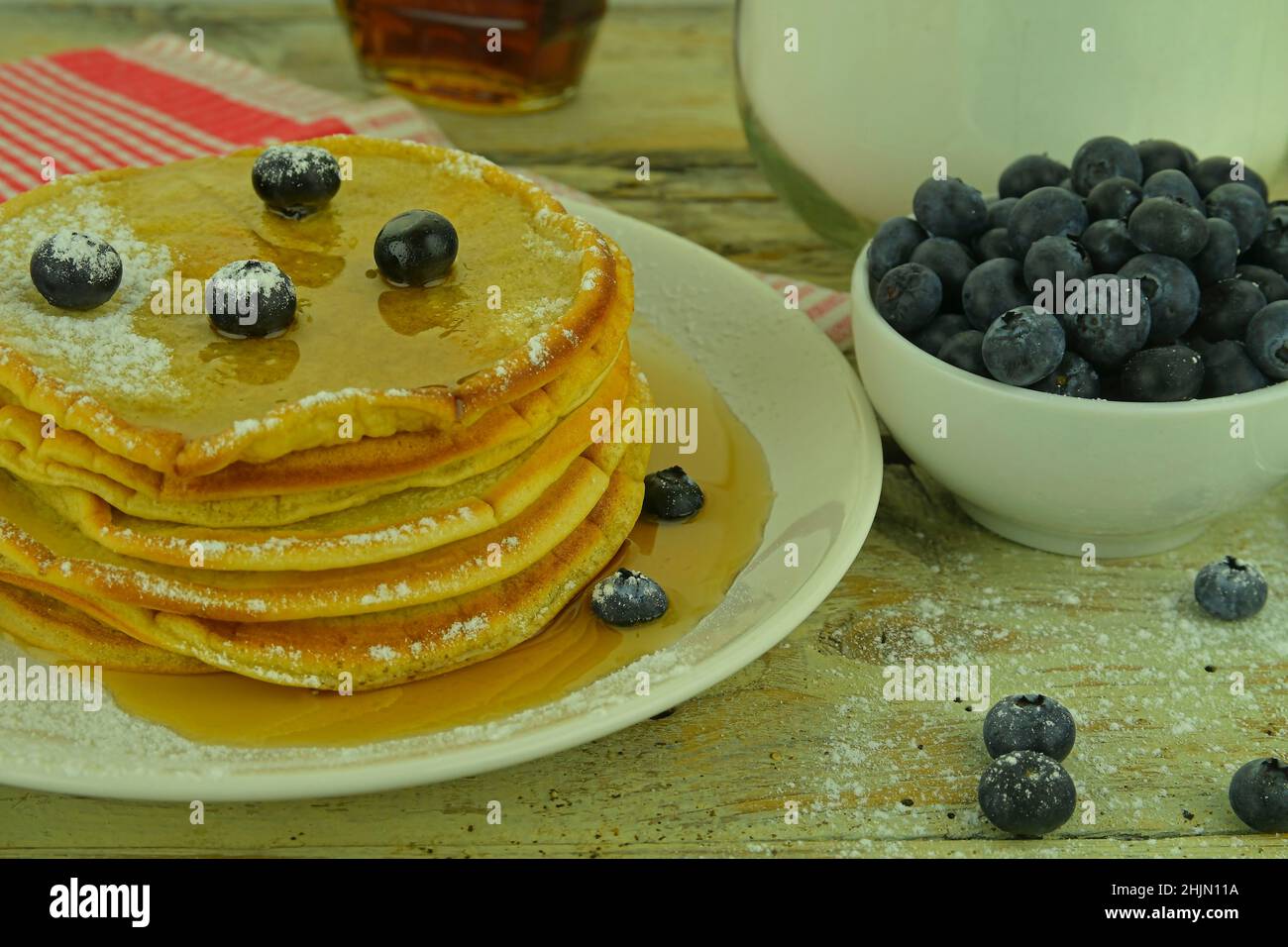 Pancake con mirtilli, sciroppo d'acero su un rustico sfondo bianco Foto Stock