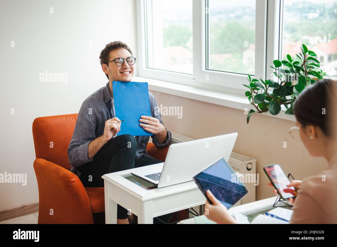 Coppia sorridente che usa un computer portatile, un tablete, il telefono paga le bollette online in app. Pagamento online. Foto Stock