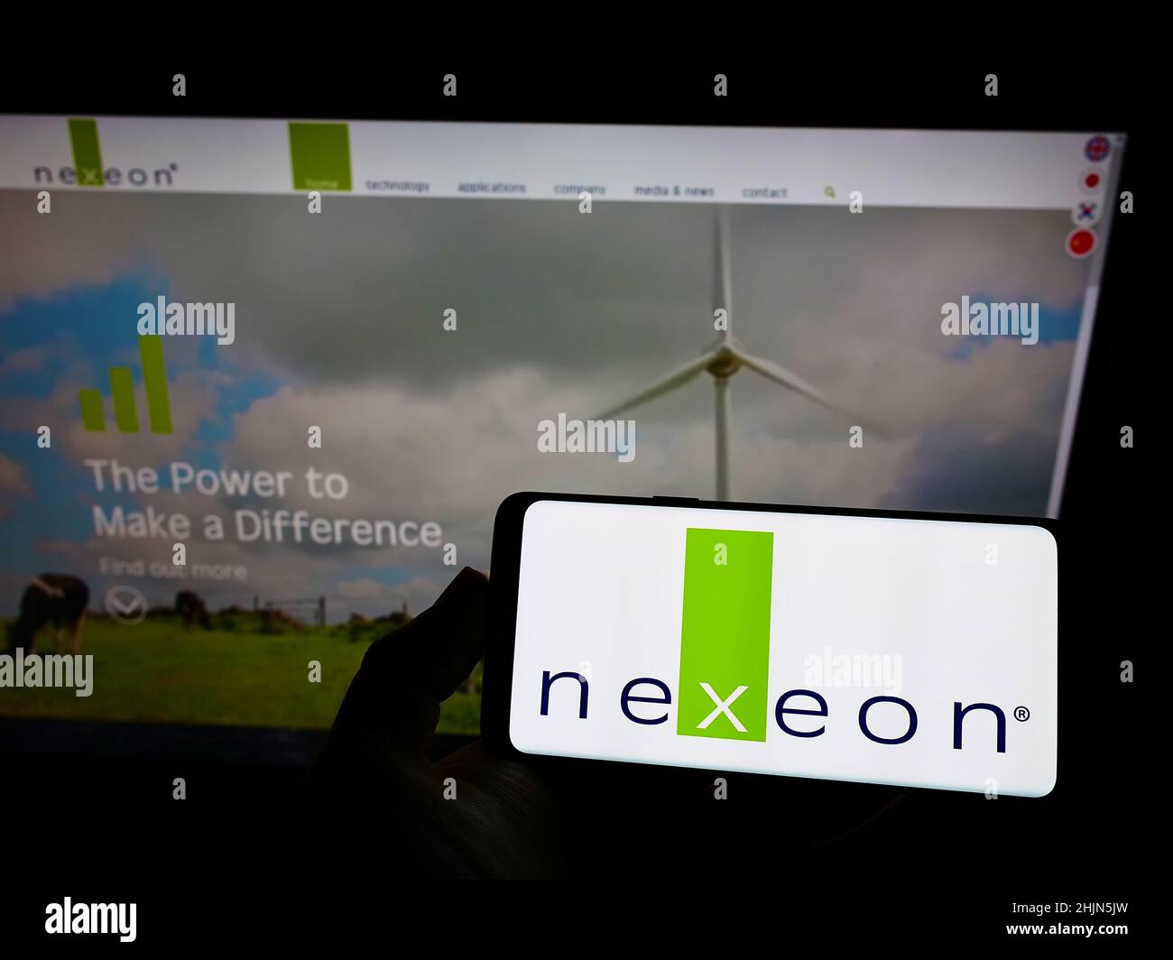 Persona che tiene lo smartphone con il logo della società britannica Nexeon Ltd. Di batterie sullo schermo di fronte al sito web. Mettere a fuoco sul display del telefono. Foto Stock