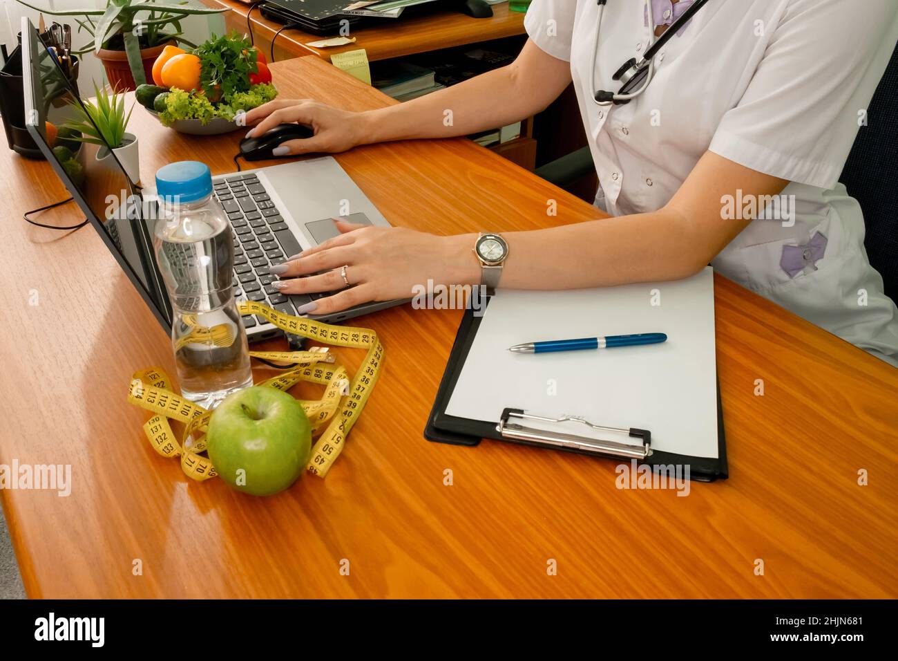 Donna dietista con metro a nastro che lavora su un piano di dieta. Perdita di peso Foto Stock