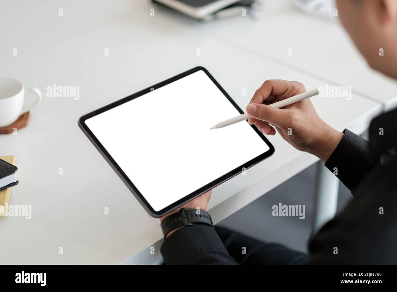 Disegno maschile asiatico su un tablet con schermo bianco e vuoto con penna stilo Foto Stock