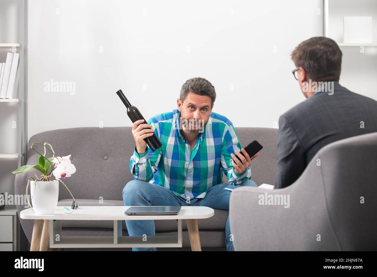 Uomo turbato alcolico seduta a psicologo in sessione di psicoterapia, triste depresso addicted ubriaco ragazzo alcol dipendenza abuso, alcolismo concetto Foto Stock