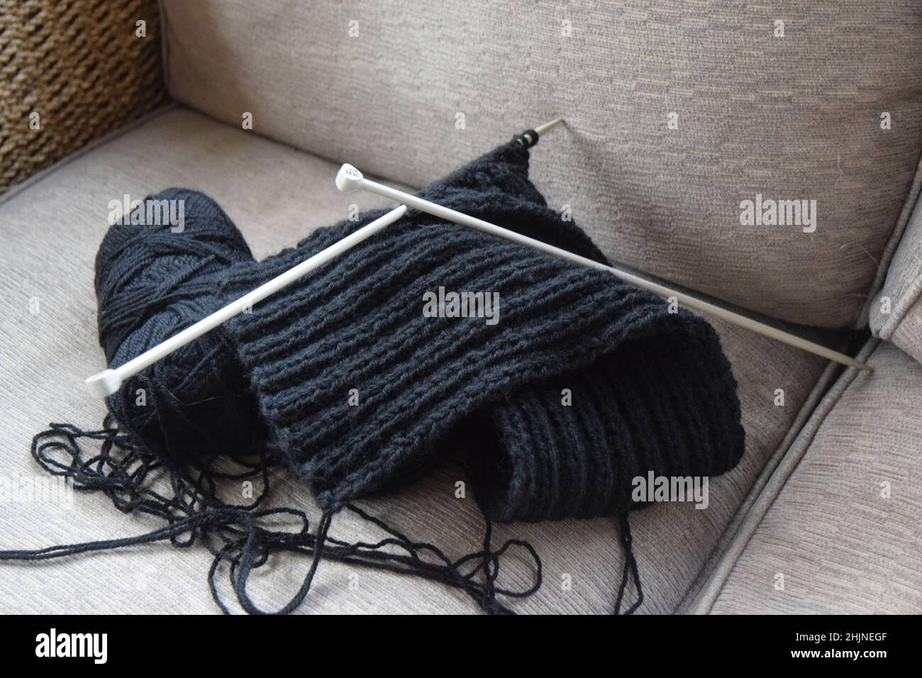 maglia e palla di lana sul divano Foto Stock