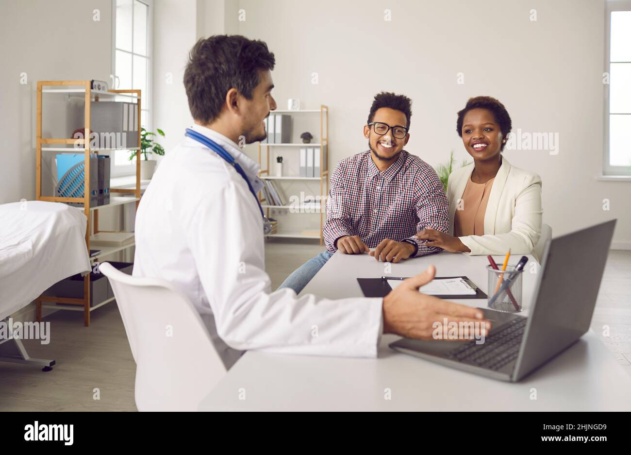 Medico maschile consultare la coppia etnica in ospedale Foto Stock