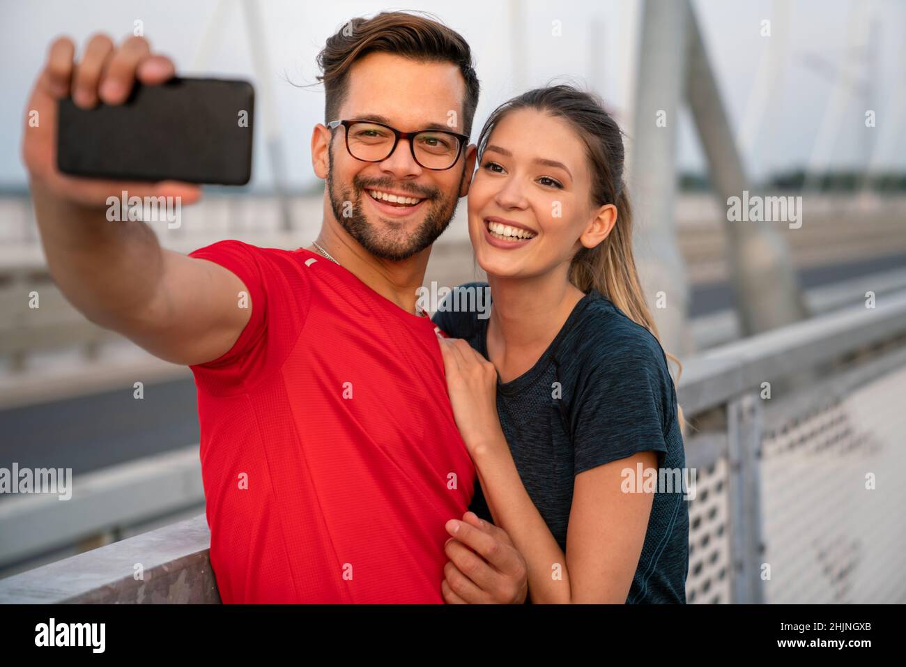 Fitness, sport, formazione, tecnologia e stile di vita. Due sorridenti persone con smartphone all'aperto Foto Stock