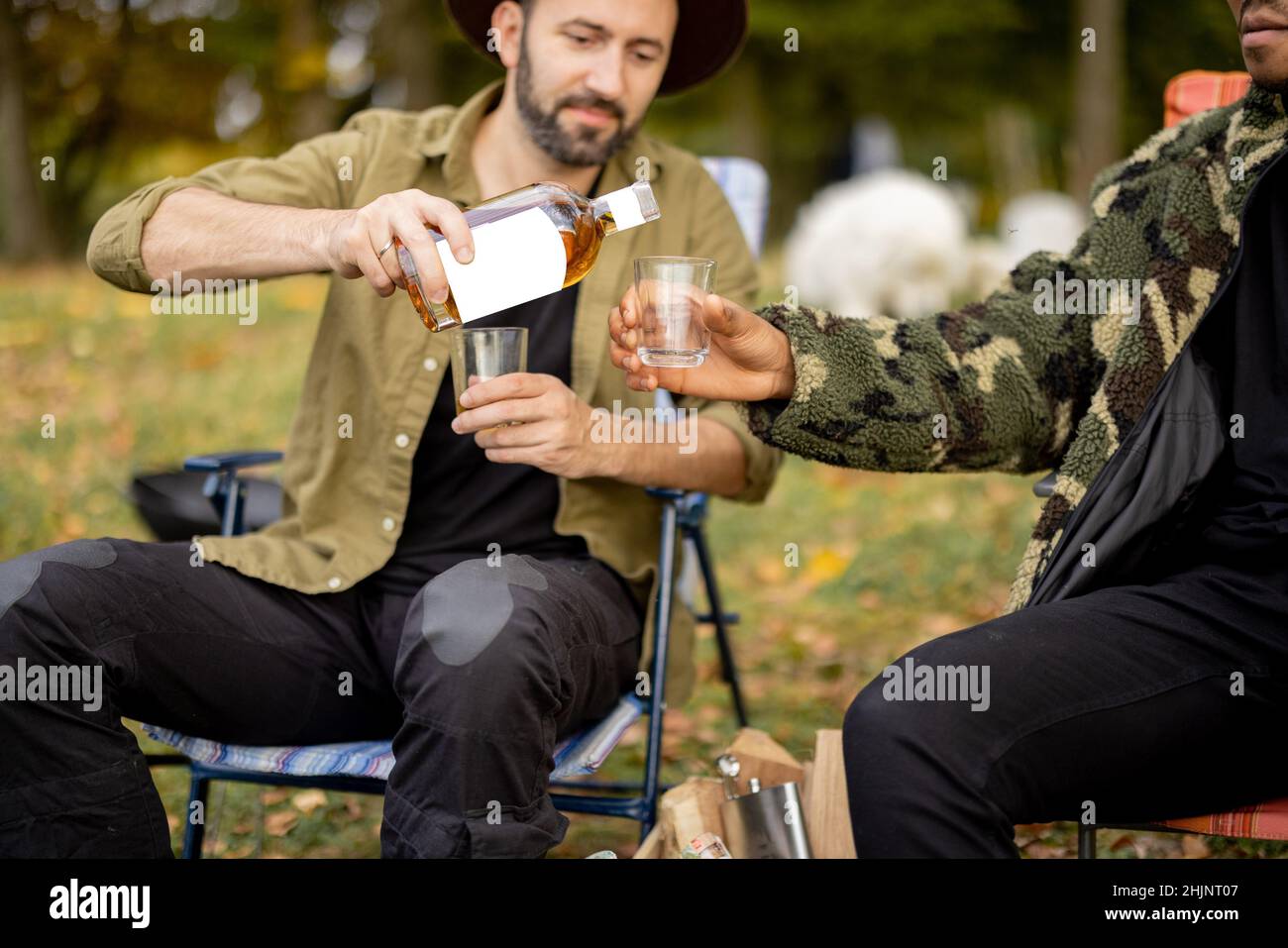 Due amici maschi che pescano con bevande alcoliche Foto Stock