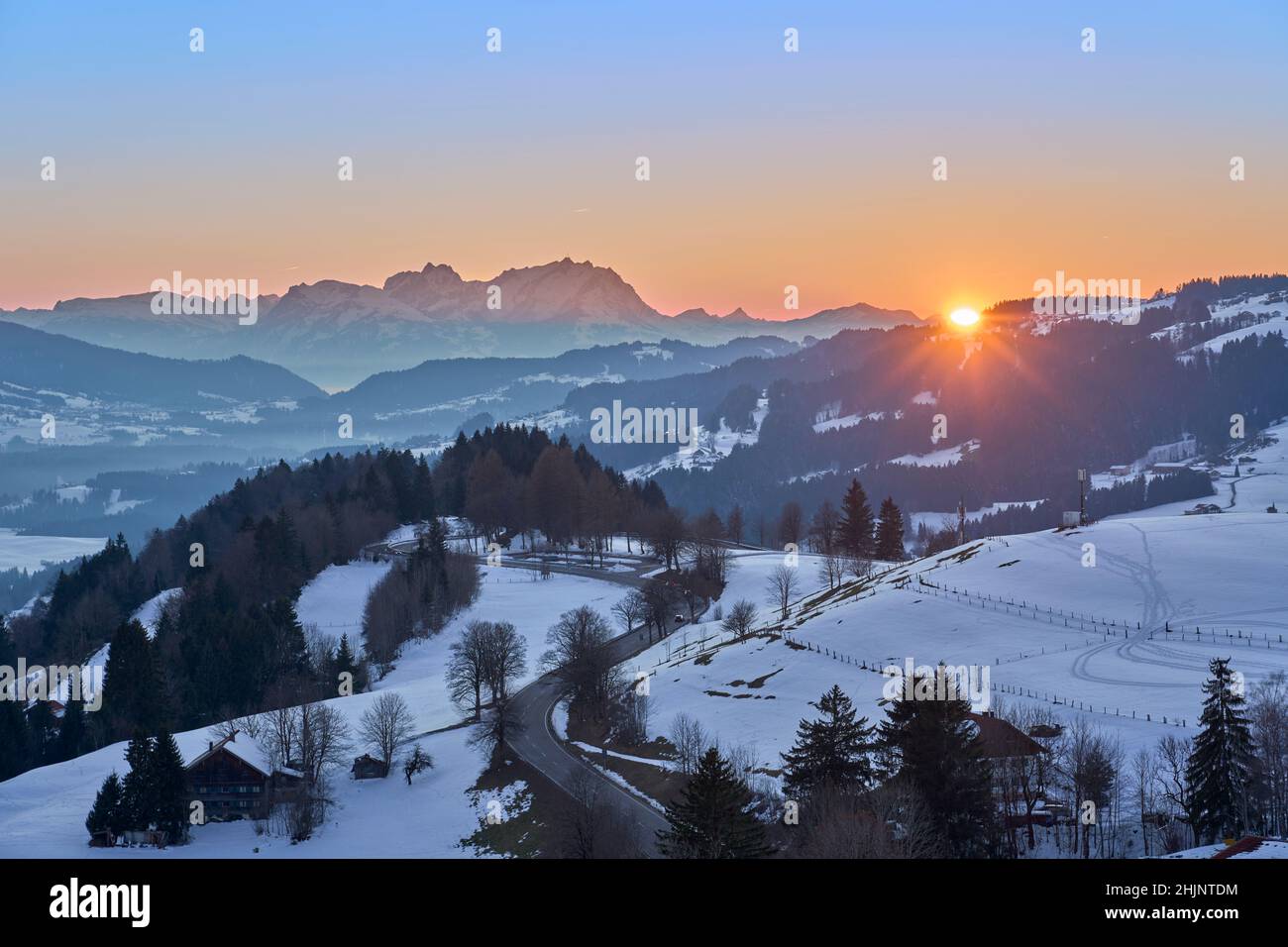 Tramonto nella nevosa zona di Bregenzer Wald di Vorarlberg, Austria, con vista spettacolare sul monte Saentis, Svizzera Foto Stock