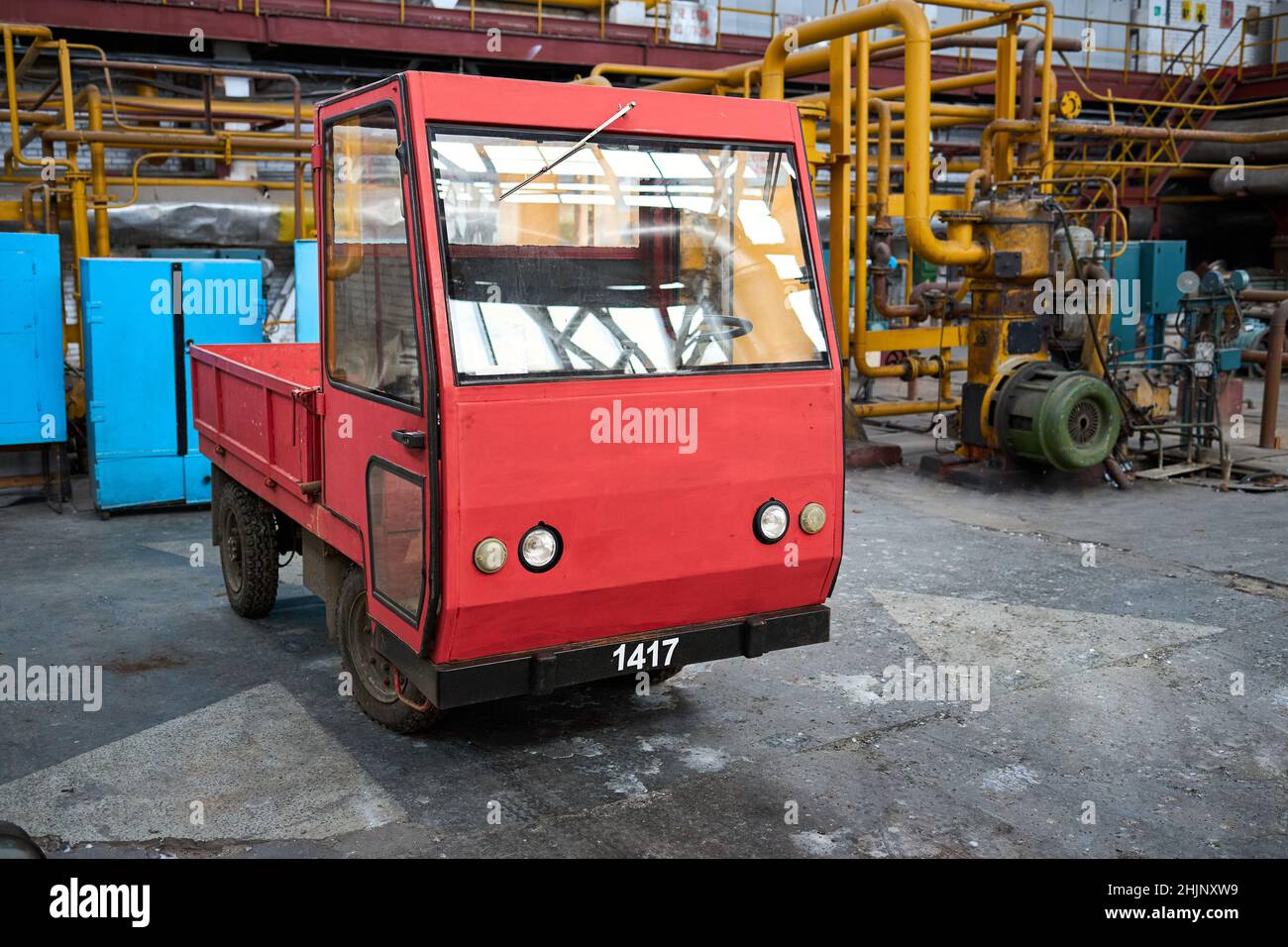 Novomoskovsk, Russia - Dicembre 2021: Veicolo elettrico da carico di vecchio stile vintage rosso si trova in magazzino presso una fabbrica o un impianto industriale Foto Stock