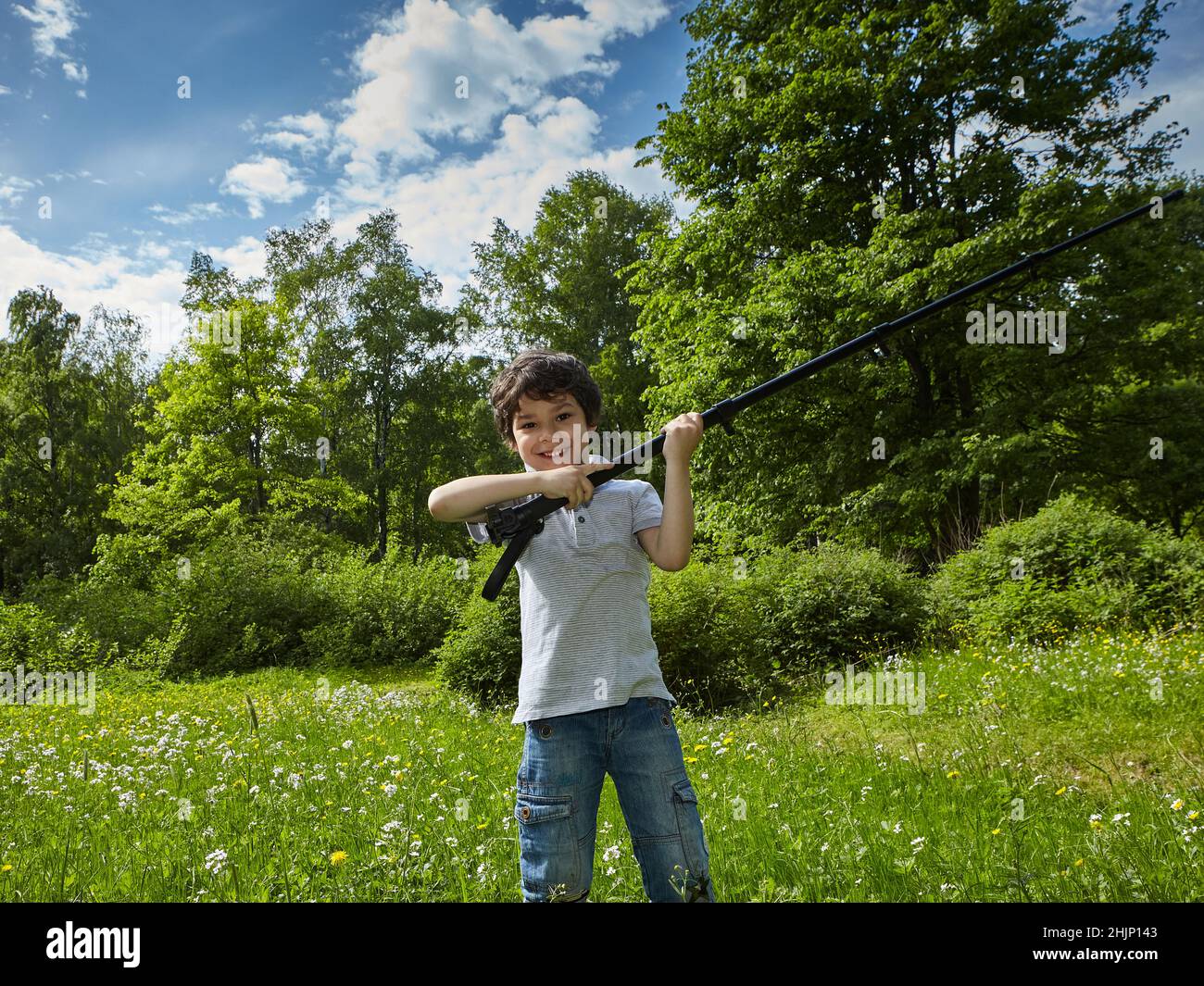 Un giovane attraente che gioca nel parco con un monopod ha fornito un modo originale di usare Foto Stock