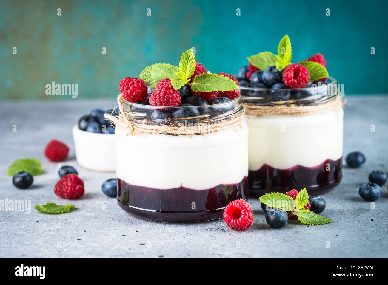 Parfait con panna e bacche fresche nel vaso di vetro. Foto Stock