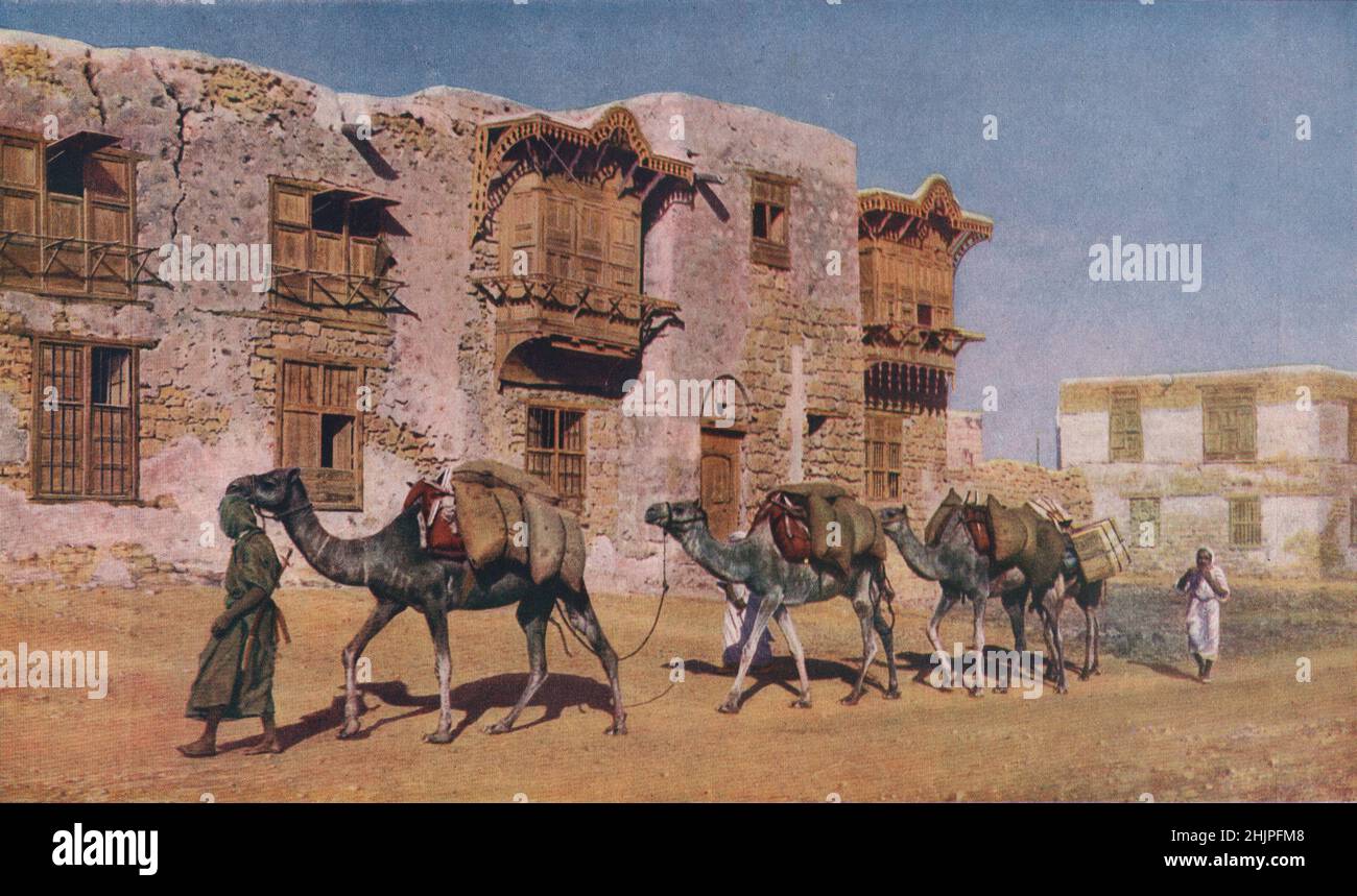 Yembo, porto della città Santa dell'Islam, Medina. Edifici ornati fiancheggiano le strade attraversate da bande di pellegrini e caravan cammello stragging. Arabia (1923) Foto Stock