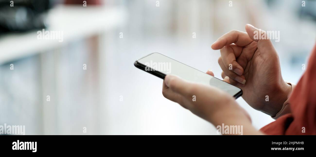 Ravvicinato donna utilizzando smartphone con touch screen con le dita delle mani, messaggi di testo, chat o social media Foto Stock