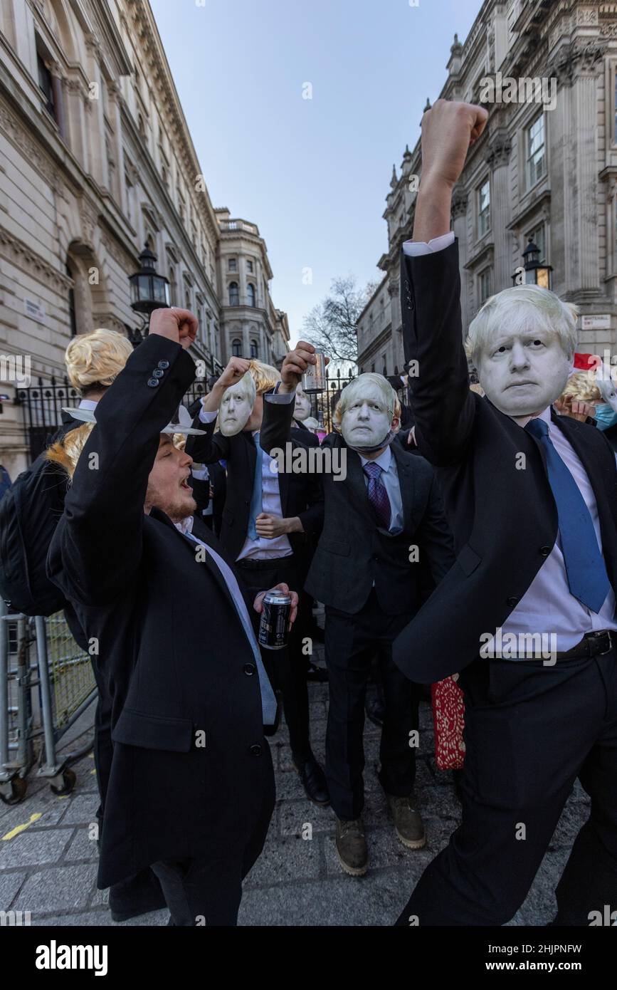 Flash-mob di 'partygate' anti-Boris Johnson manifestanti indossando floppy biondo wig e Boris Johnson facemasks fuori le porte di Downing Street, Regno Unito Foto Stock
