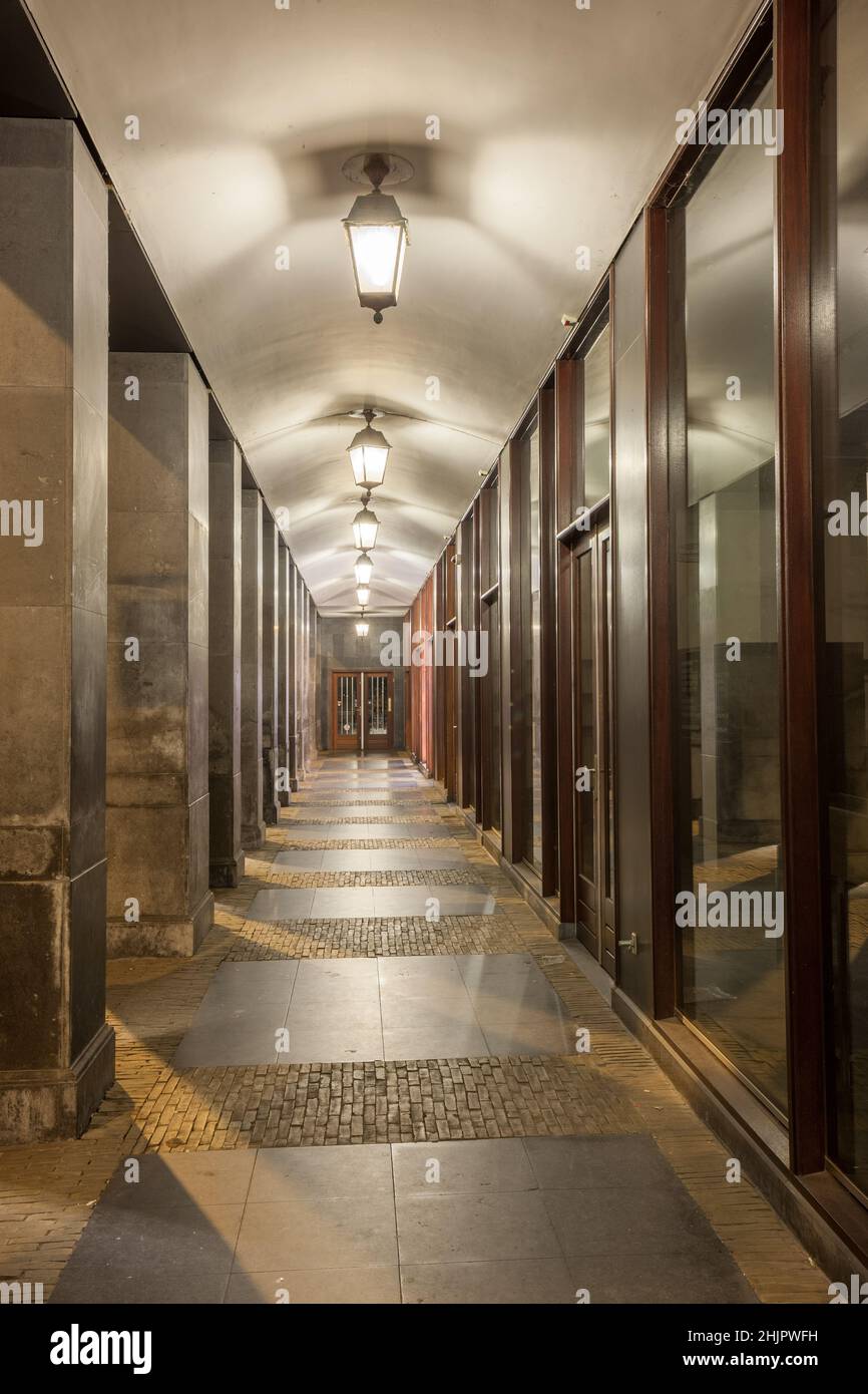 Passaggio pedonale esterno moderno di un edificio con colonne e finestre di vetro Foto Stock