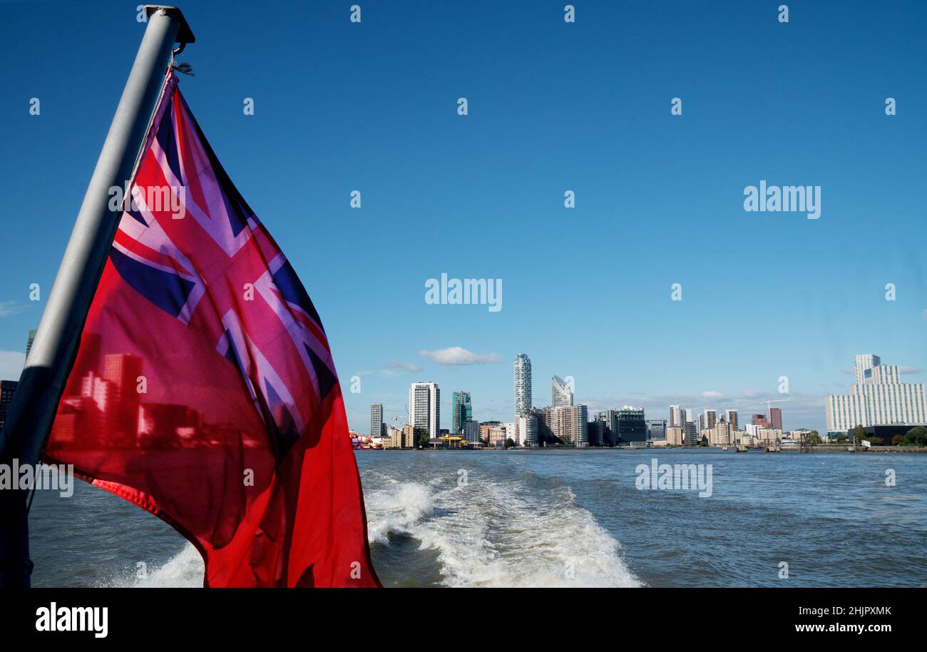 Skyline di Londra dal Tamigi con bandiera rossa in primo piano Foto Stock