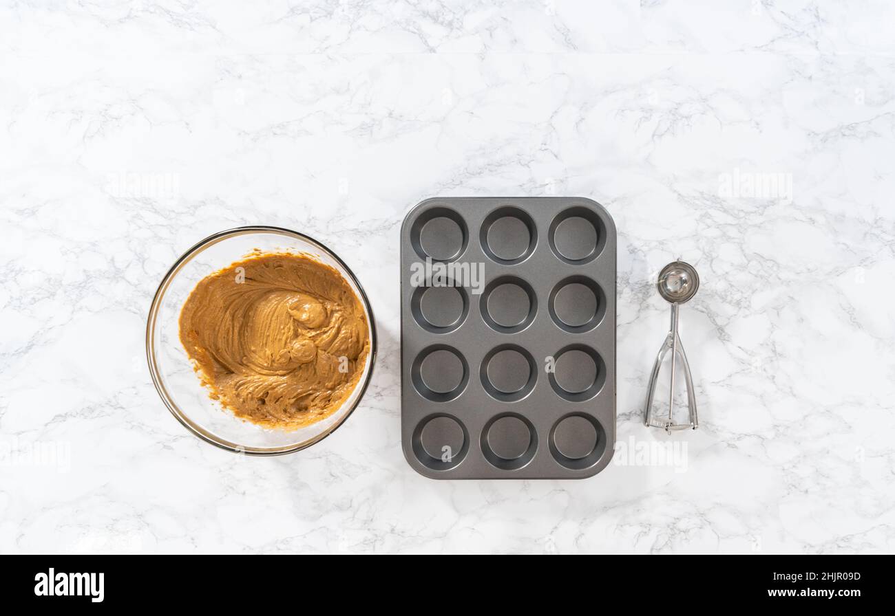 Foderare la teglia per cupcake con i rivestimenti per cupcake in lamina per cuocere i cupcake di pan di zenzero. Foto Stock