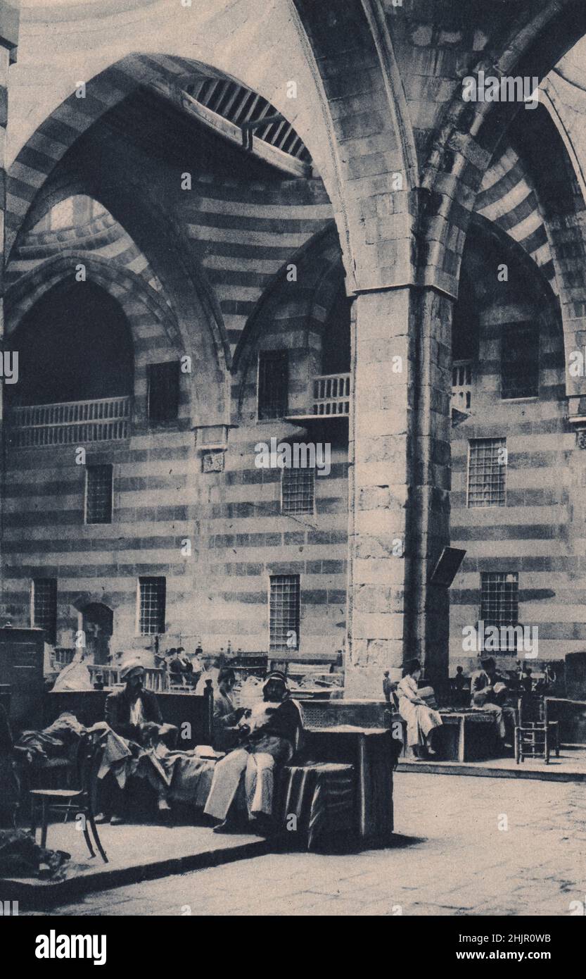 Il Khan As'ad Pasha è il più bello dei Khan con le sue colonne di marmo nero e giallo, Round la corte sono file di negozi. Siria. Damasco (1923) Foto Stock