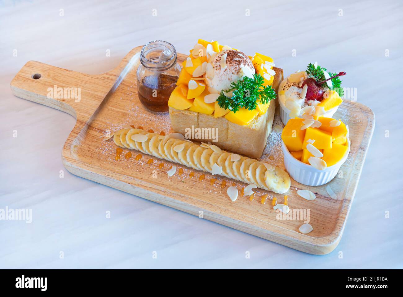 Toast al miele di Mango Tango, toast al miele con mango, gelato alla vaniglia e dessert alla panna montata. Foto Stock