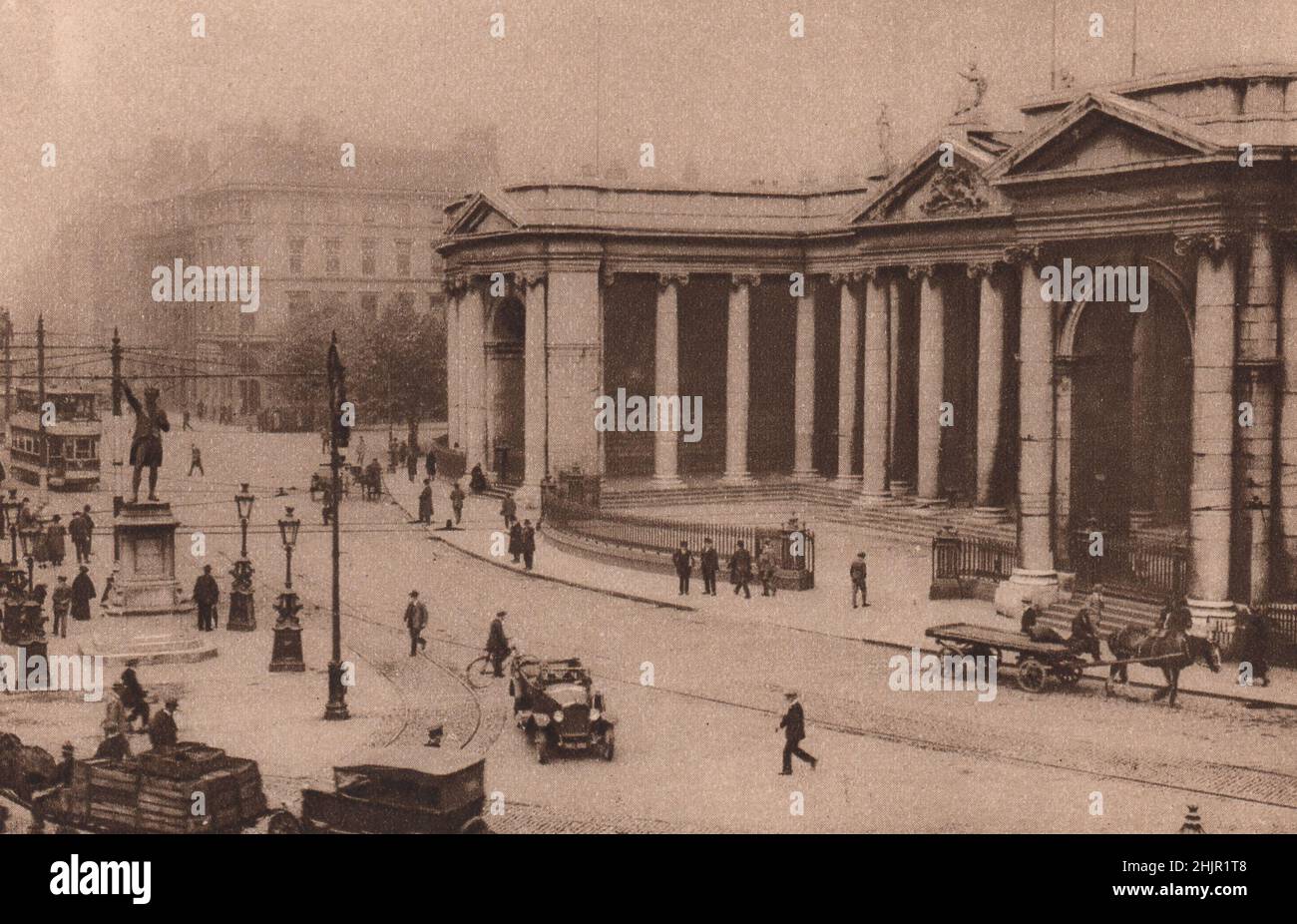 Sul lato nord del college Green, dietro la statua di Grattan, si estende la nobile facciata colonnata Ionica della Banca d'Irlanda. Dublino (1923) Foto Stock