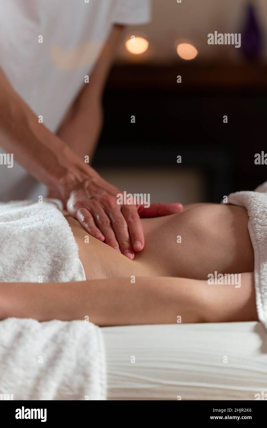 Una donna massaggiatrice che fa un massaggio ad olio ad un'altra donna sullo stomaco Foto Stock