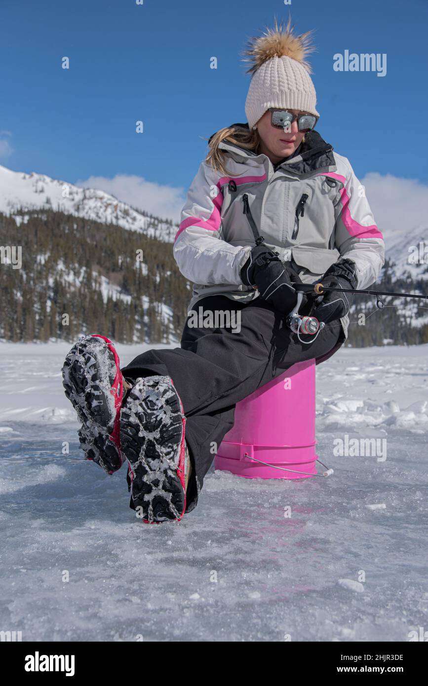 Donna ghiaccio pescato su secchio rosa in Colorado Foto Stock