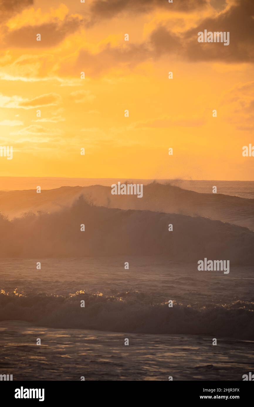 Misty Tramonto sulle onde sulla costa nord di Oahu Foto Stock