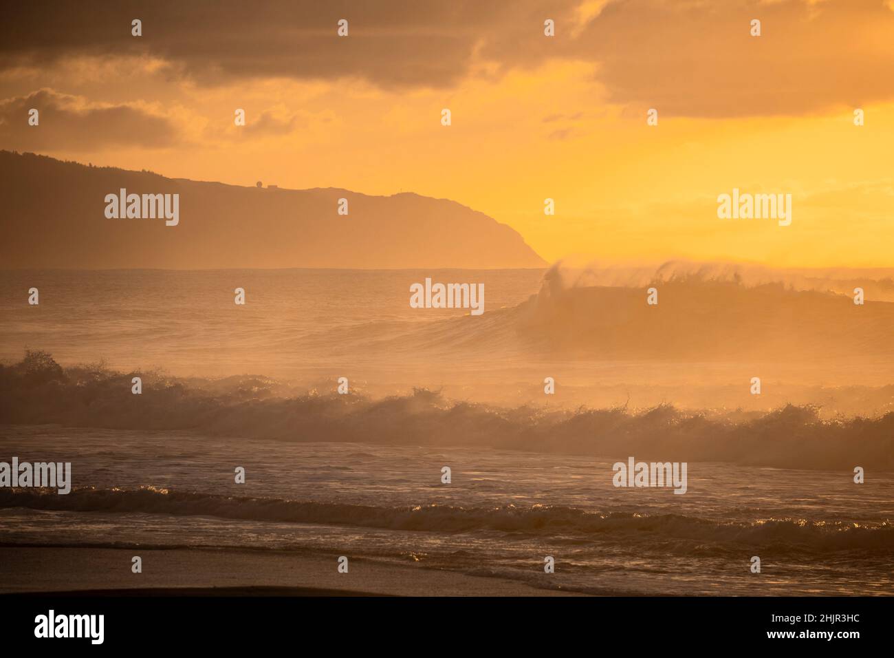 Misty Tramonto sulle onde sulla costa nord di Oahu Foto Stock