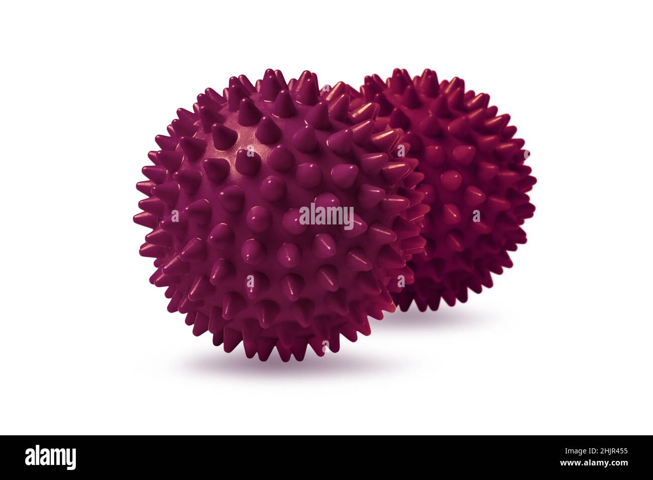 Due palline rosse per massaggio spinoso isolate su bianco. Concetto di fisioterapia o fitness. Primo piano di una sfera di gomma colorata per denti di cane su un colore bianco Foto Stock