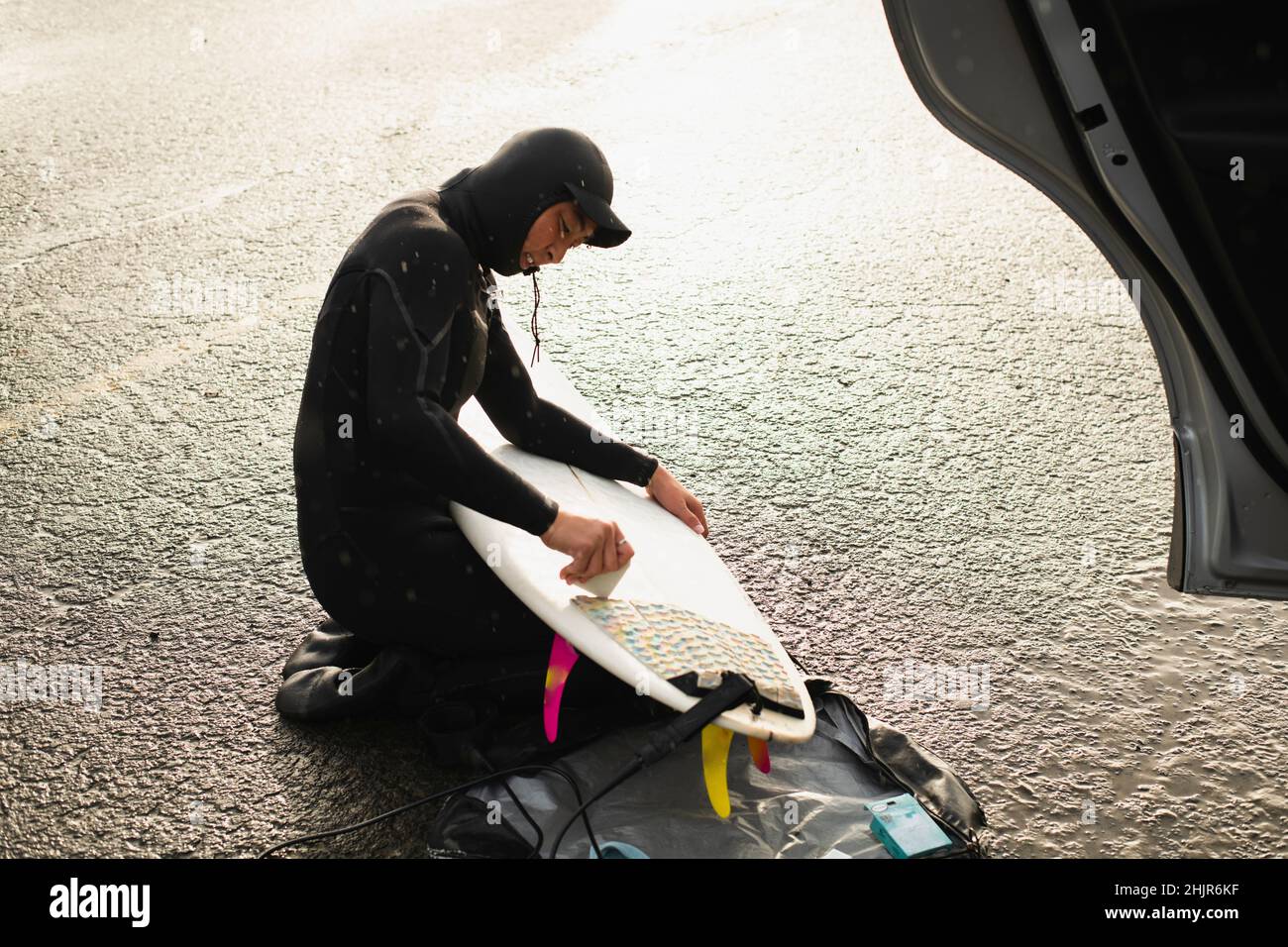 Giovane donna che si prepara a surf ceretta surf surf bordo costiero Oregon Foto Stock